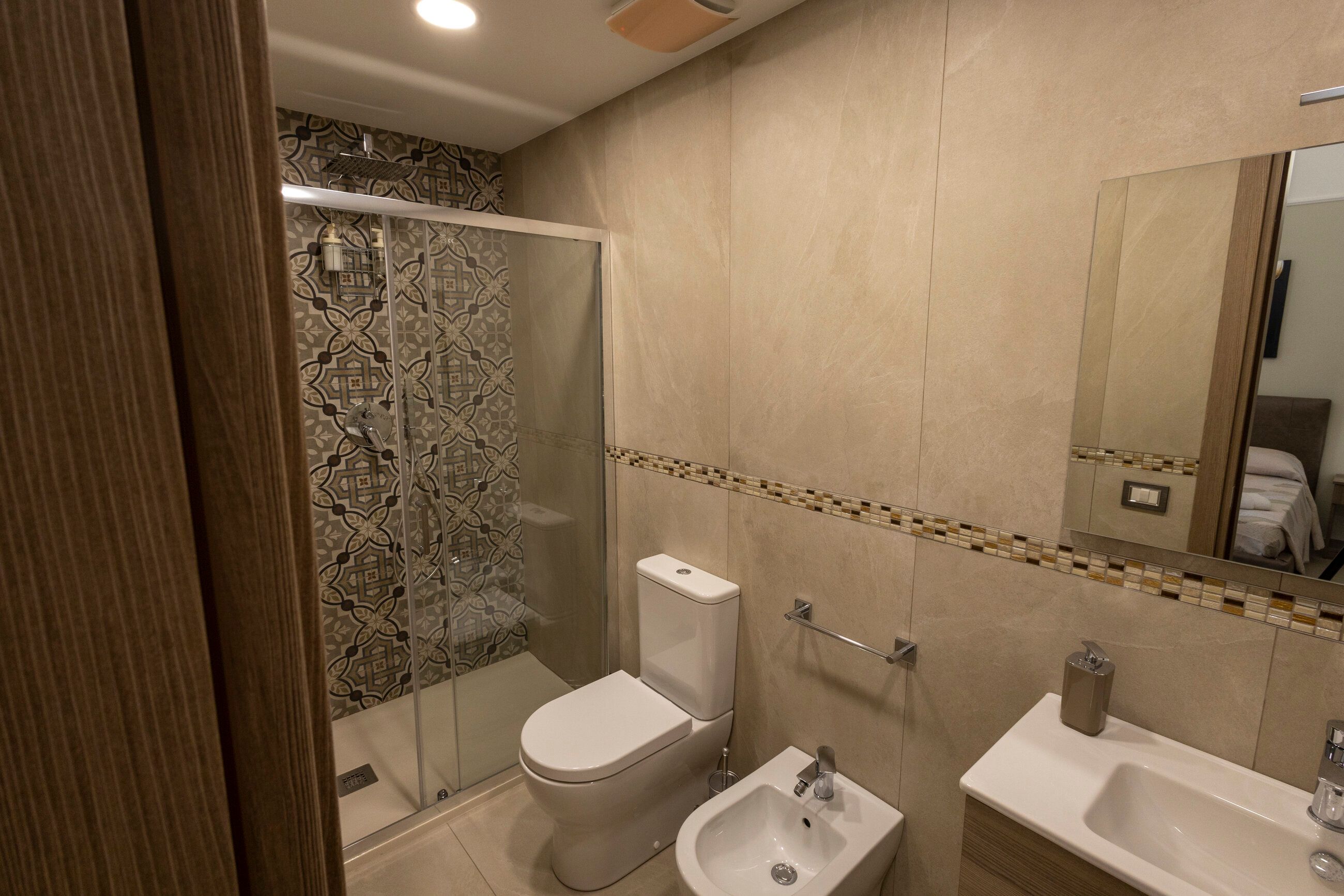 Il bagno privato della camera Miriana, con pannelli doccia a motivi floreali