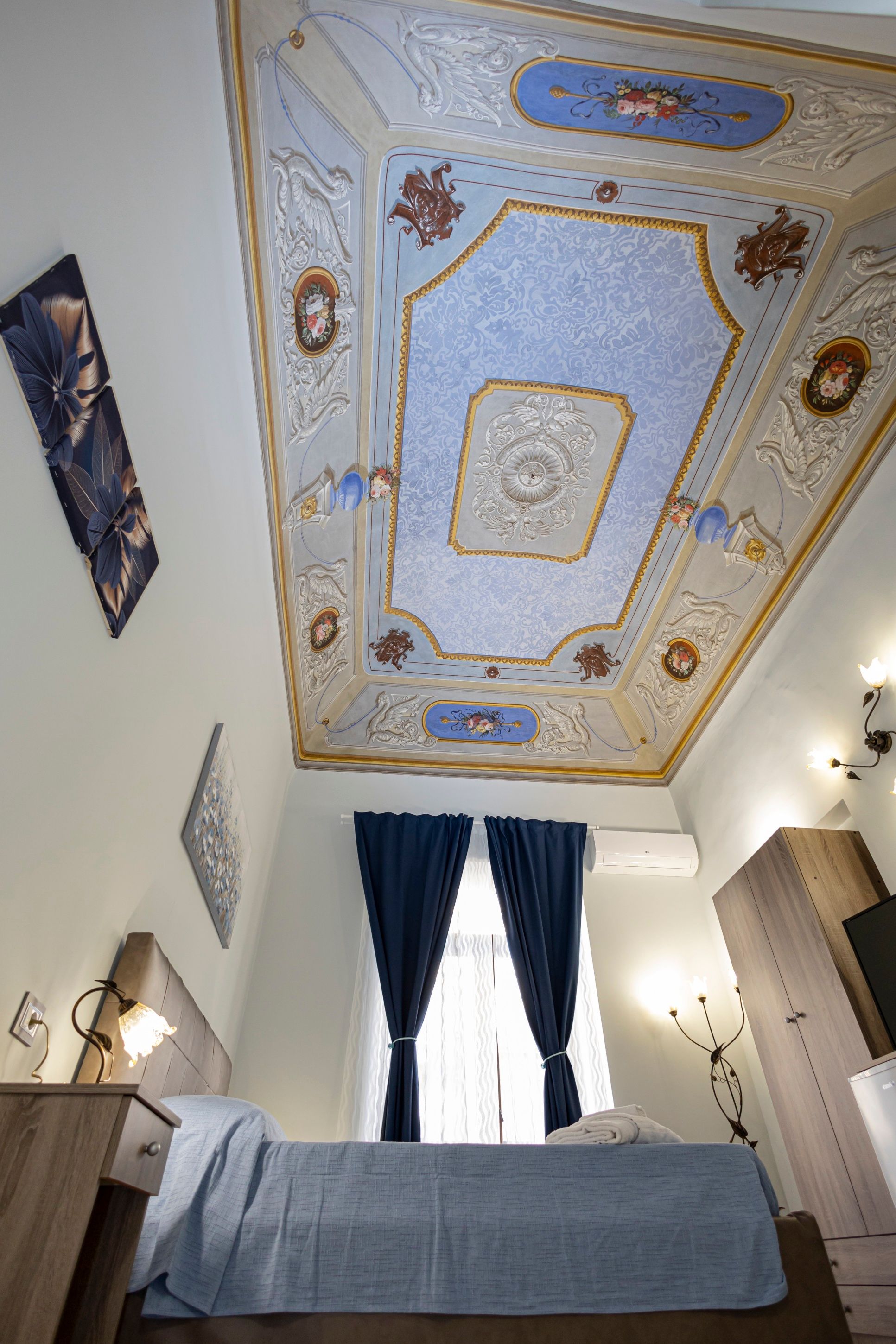 Il soffitto affrescato del Settecento della suite Aurora, con stucchi e motivi floreali in azzurro e oro